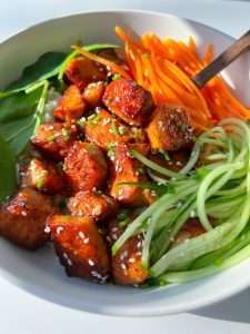 Honey garlic salmon bowl with rice, carrots, cucumber, sesame seeds