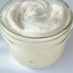 A small glass jar filled with creamy white Egg Free Mayo, its smooth, swirled surface invitingly displayed against a white background.