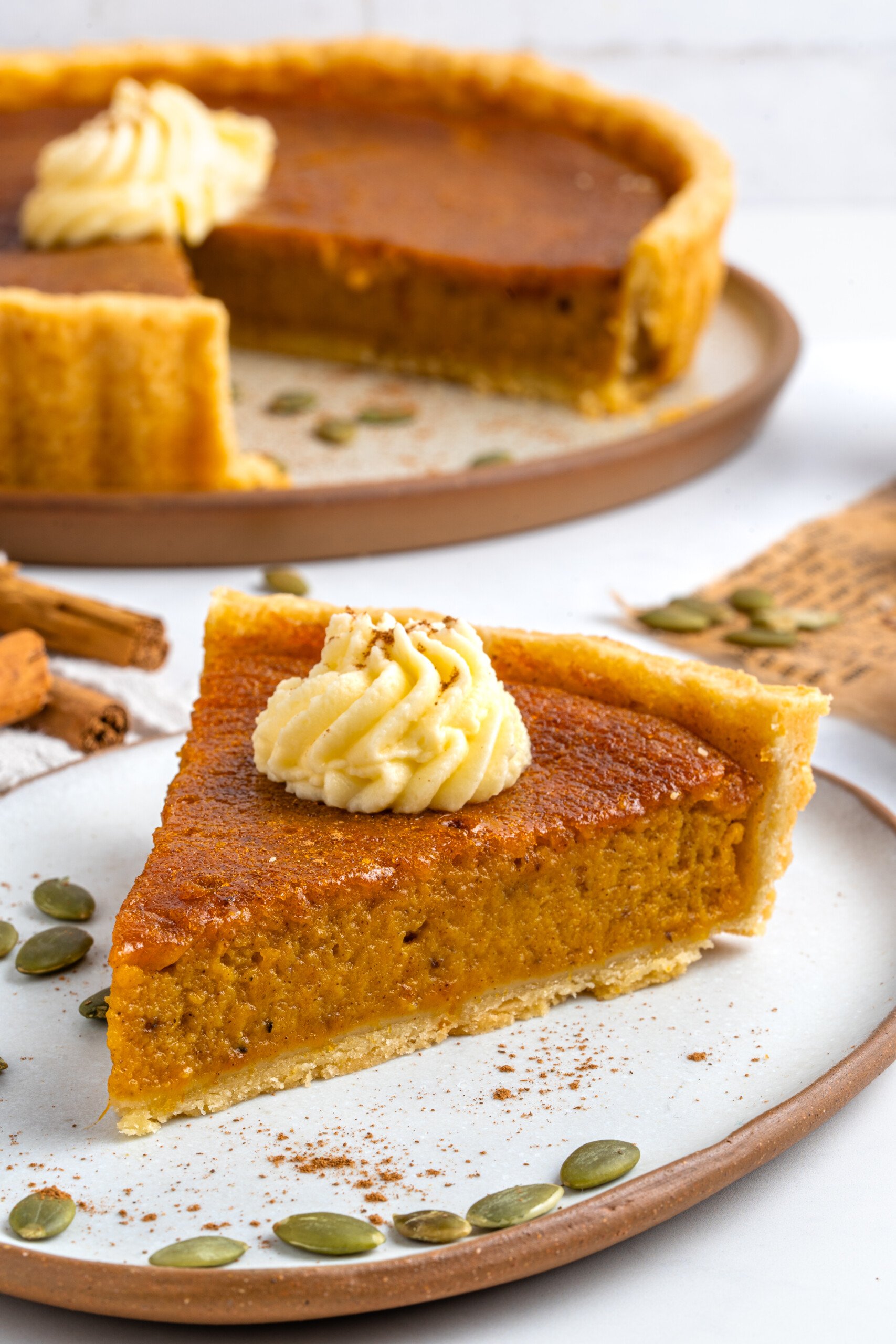 a plate with a slice of pumpkin pie on top. 