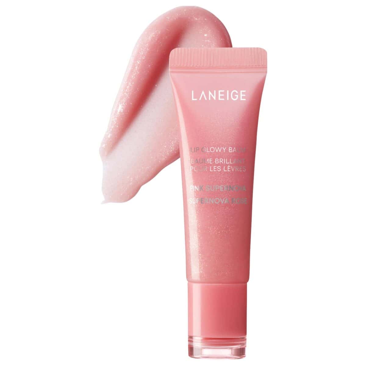 A pink tube of Laneige Lip Glowy Balm, labeled “Pink Supernova,” with a smear of the shiny balm beside it. Discover this radiant look and enjoy Exclusive Deals on your next purchase.