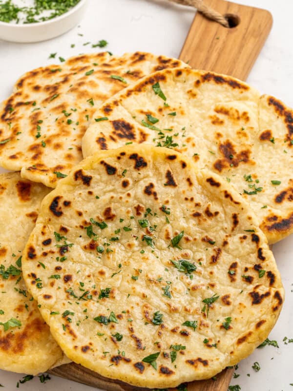 Delicious homemade naan with melted cheese, served hot and garnished with fresh herbs. Perfect for comforting meals.