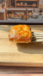 a person showing the inside of a crispy Rice Paper Tunacado melt