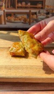 a person showing the inside of a crispy Rice Paper Tunacado melt