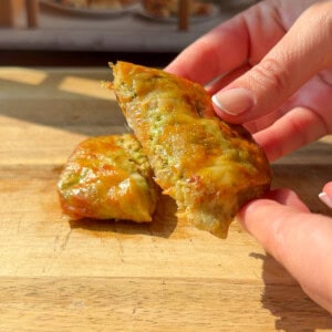 a person showing the inside of a crispy Rice Paper Tunacado melt