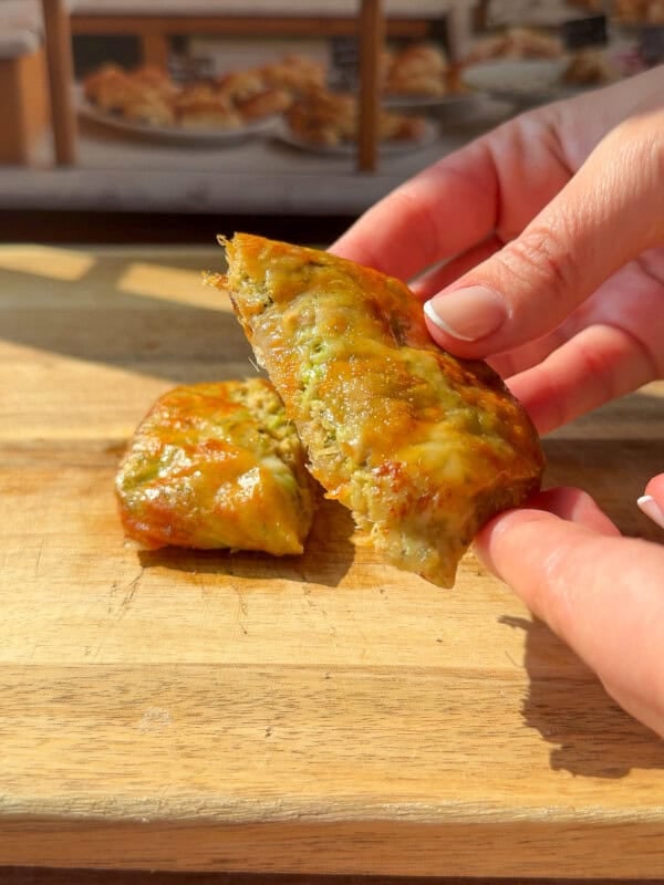 a person showing the inside of a crispy Rice Paper Tunacado melt