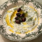 Tzatziki dip with Kalamata olives and dill on decorative plate