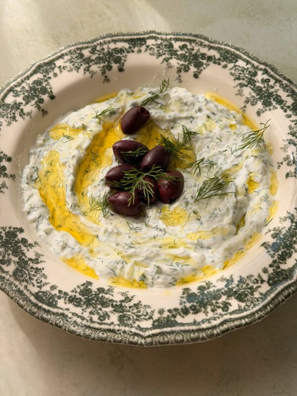 Tzatziki dip with Kalamata olives and dill on decorative plate