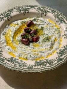 Creamy tzatziki with Kalamata olives and dill on decorative plate