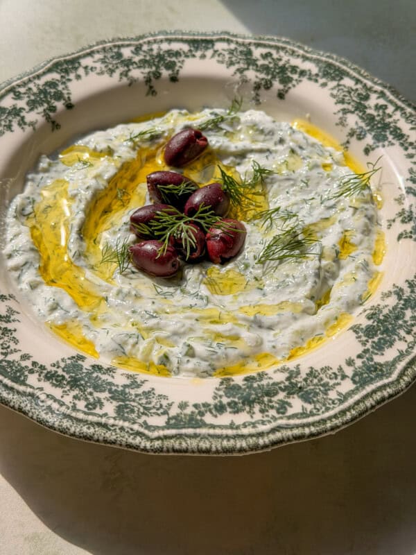 Creamy tzatziki with Kalamata olives and dill on decorative plate