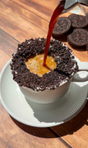 Espresso poured into Oreo cookie-rimmed coffee cup