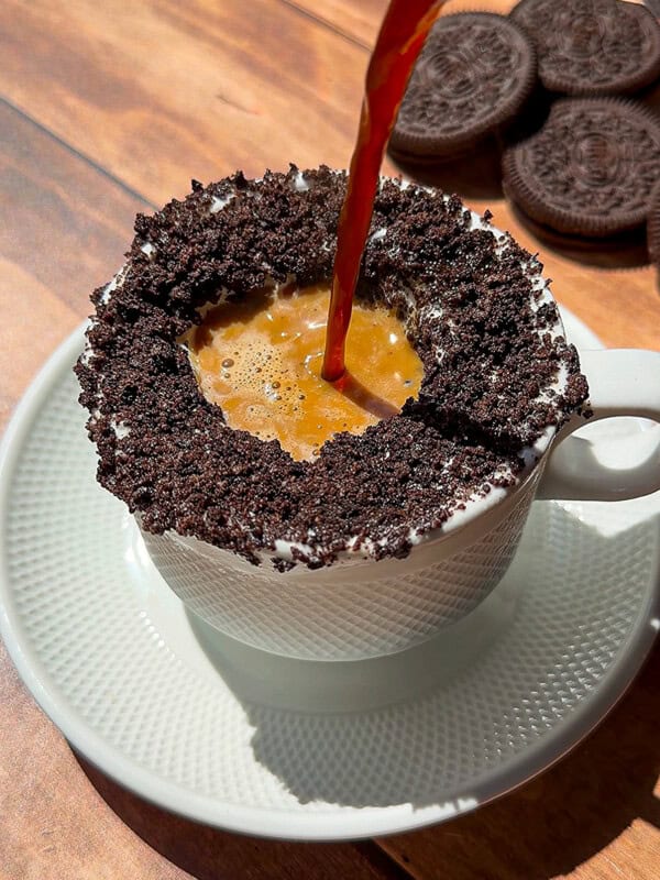 Espresso poured into Oreo cookie-rimmed coffee cup