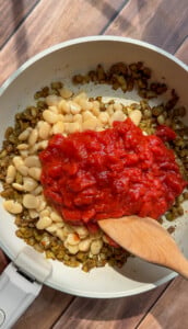 White beans and crushed tomatoes added to sautéed vegetables