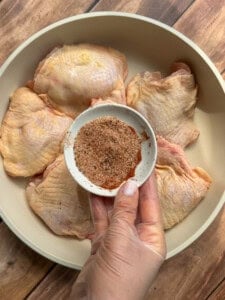 chicken thighs in a pan with seasoning