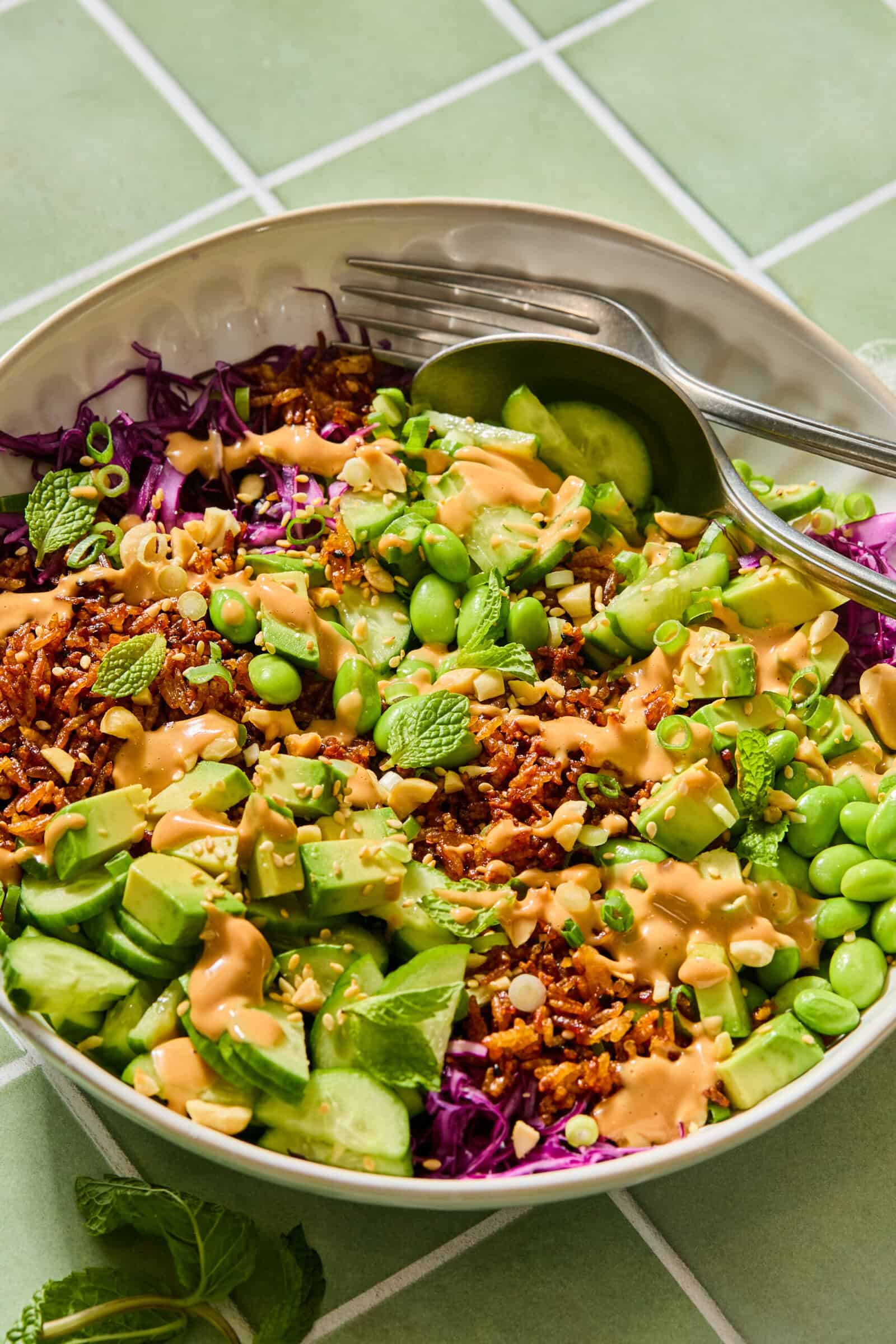 Colorful Asian rice bowl with avocado, edamame, and peanut sauce