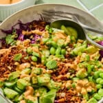 Vibrant rice bowl with avocado, edamame, and peanut sauce