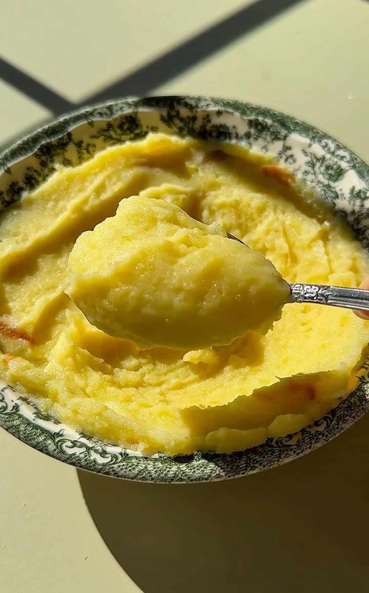 Creamy mashed potatoes in decorative green floral bowl