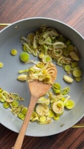 Sautéed leeks and garlic in a gray nonstick pan